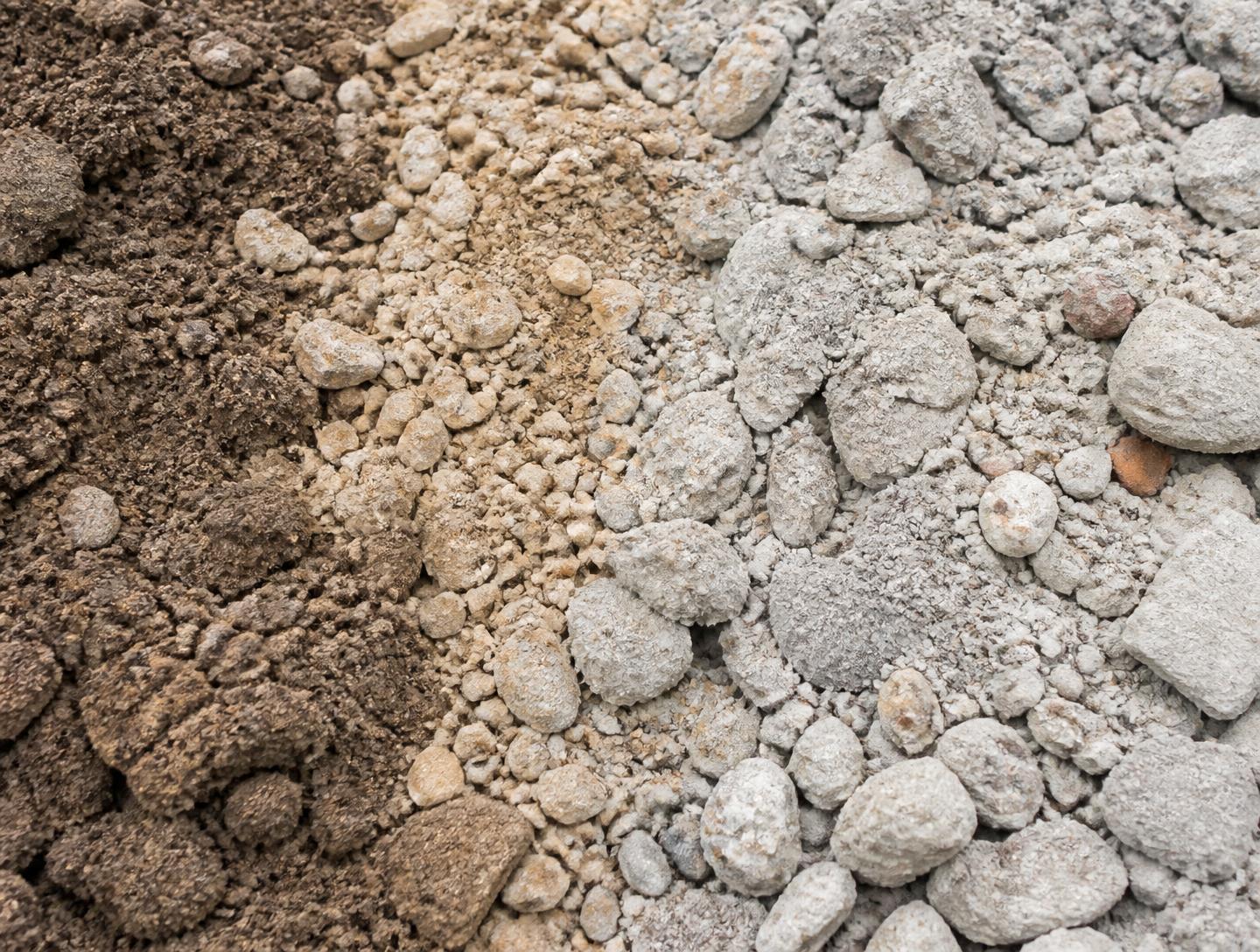 Nebeneinander liegende Materialien: Mutterboden, Sand und aufbereiteter Bauschutt